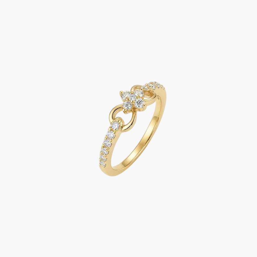 A delicate gold ring featuring a small floral motif set with clear stones, accented by a curved row of small pavé-set stones along the band, shown on a plain white background.