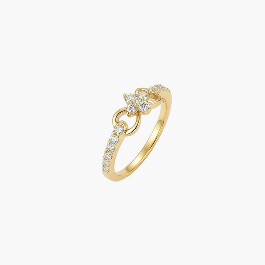 A delicate gold ring featuring a small floral motif set with clear stones, accented by a curved row of small pavé-set stones along the band, shown on a plain white background.