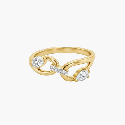 A yellow gold ring with an infinity symbol design, featuring two heart-shaped diamonds and a small row of round diamonds on the band, set against a plain white background.