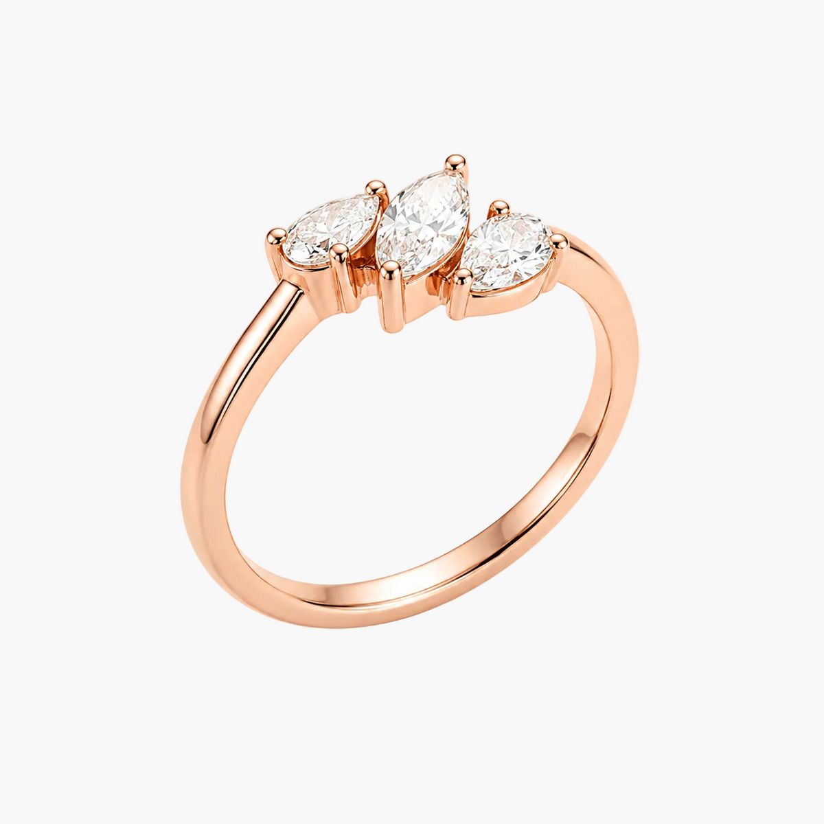 A rose gold ring featuring three marquise-cut clear gemstones in a row, set on a polished band, shown against a plain white background.