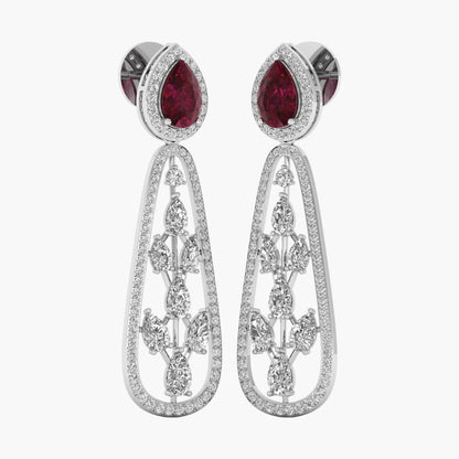Pair of earrings with red gemstones and intricate silver designs on a white background