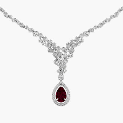 Diamond necklace with a central red gemstone on a white background