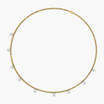 Gold chain necklace with small pearls on a white background