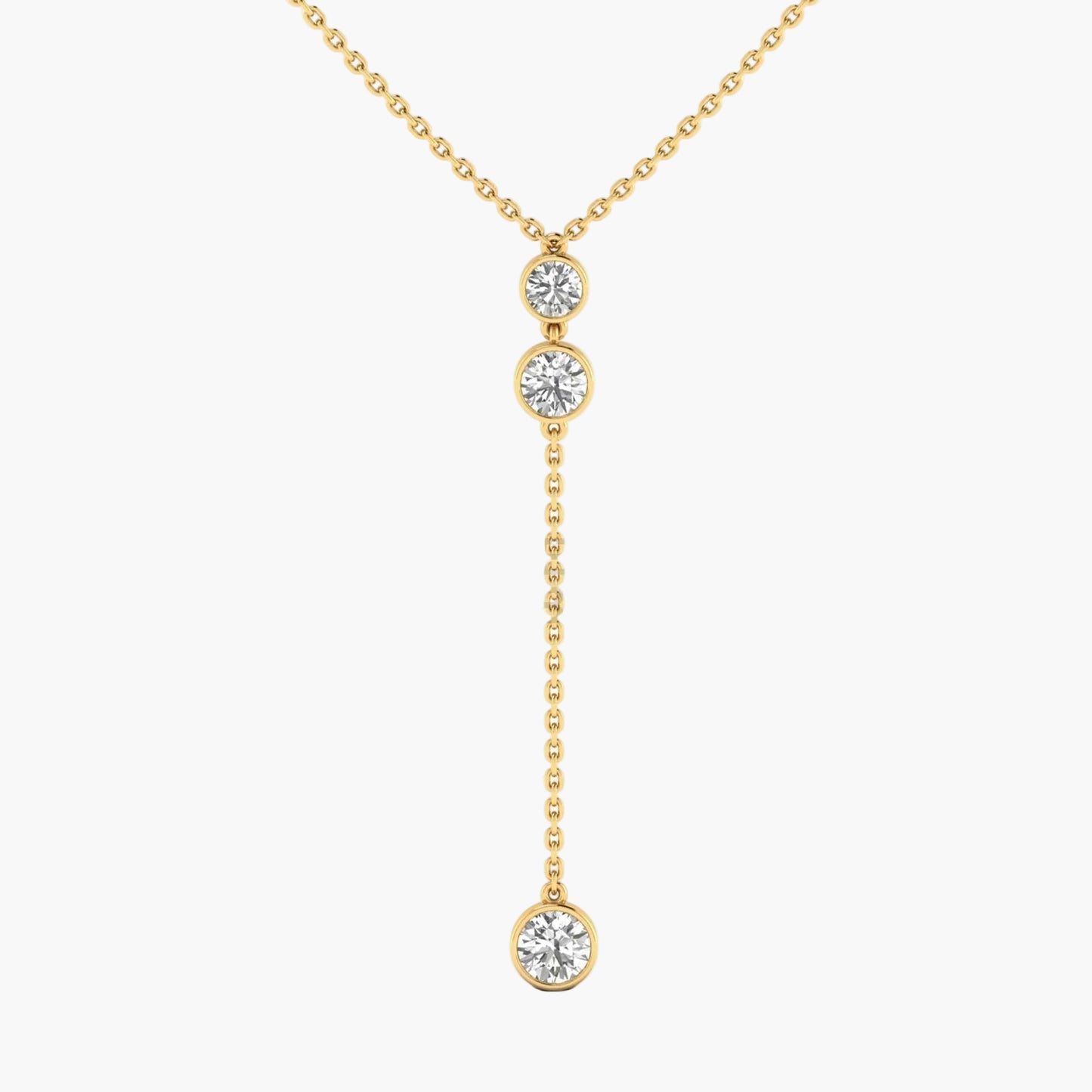 Gold necklace with three diamond pendants on a white background