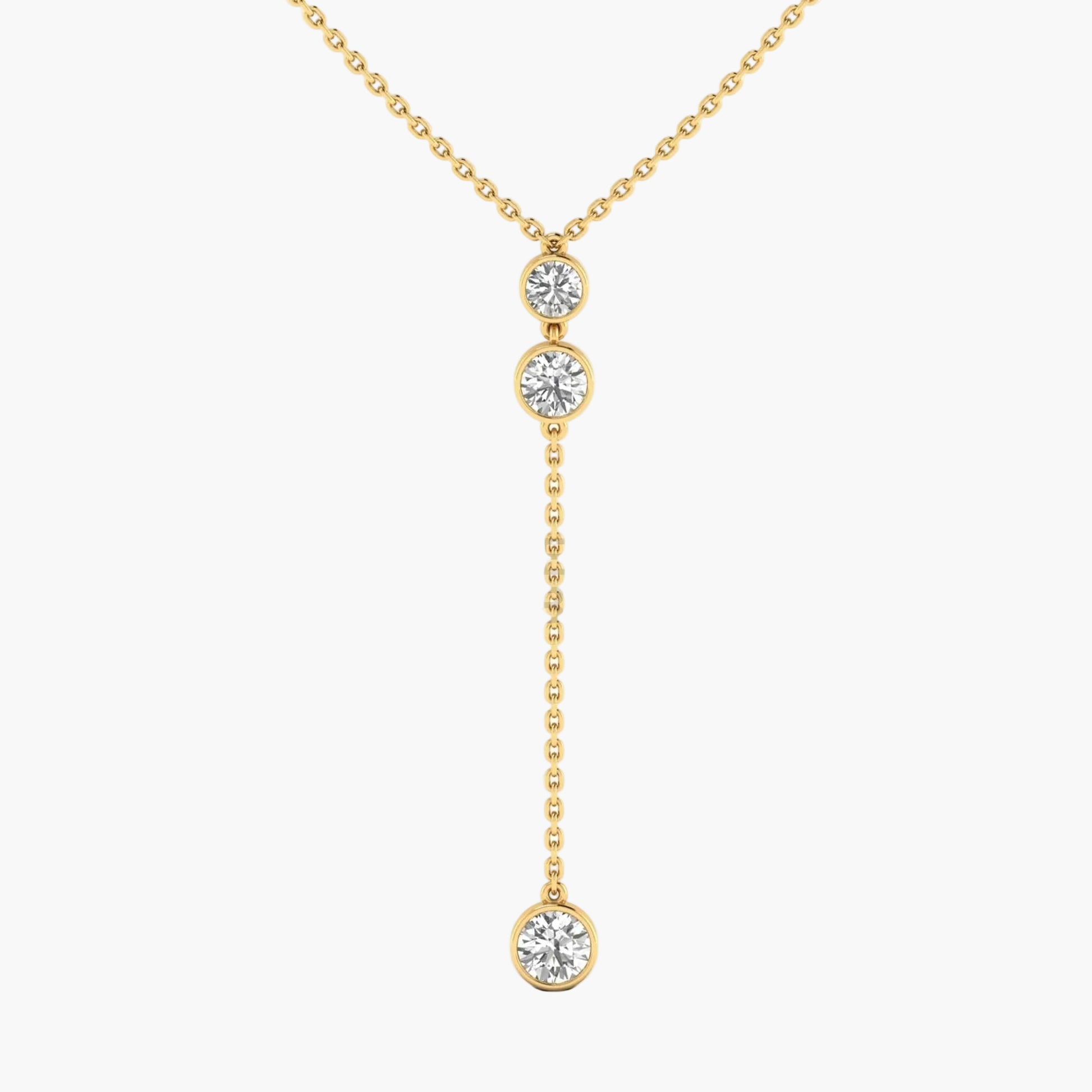 Gold necklace with three diamond pendants on a white background
