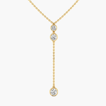 Gold necklace with three diamond pendants on a white background