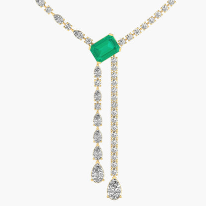 Gold necklace with emerald and diamond pendants on a white background