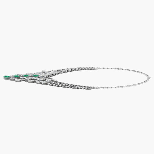 Silver necklace with green gemstones on a white background