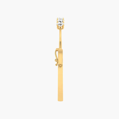 Gold earring with a clear gemstone on a white background
