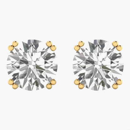 A pair of round-cut diamond stud earrings in yellow gold prong settings, shown on a plain white background with a faint GREENE LAB watermark.
