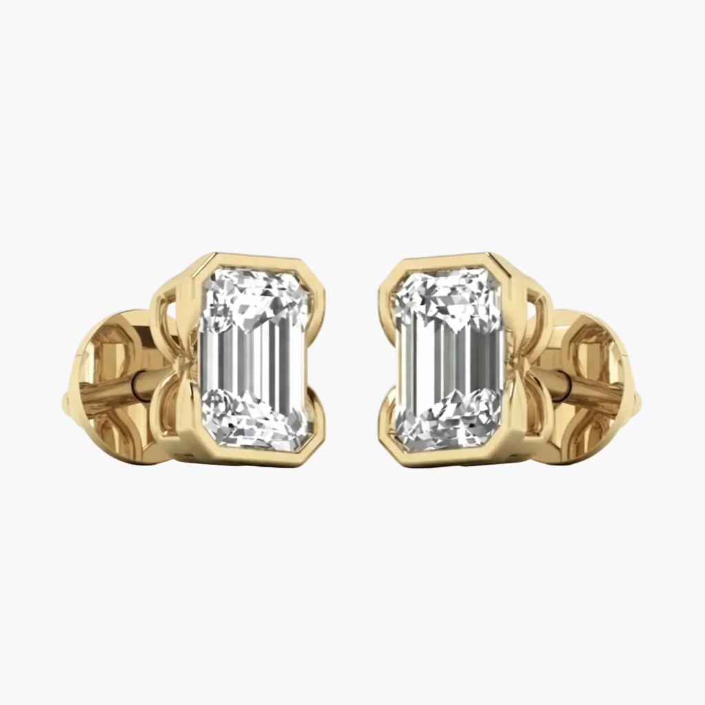 A pair of yellow gold stud earrings featuring rectangular baguette-cut clear gemstones in a bezel setting, shown against a plain white background.