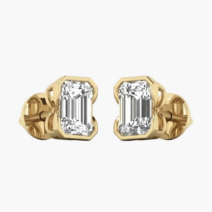 A pair of yellow gold stud earrings featuring rectangular baguette-cut clear gemstones in a bezel setting, shown against a plain white background.