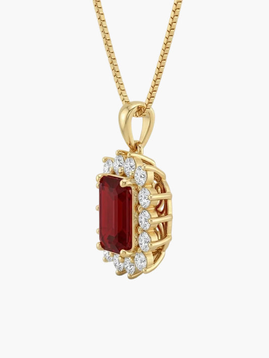 Gold pendant with a red gemstone and diamonds on a white background