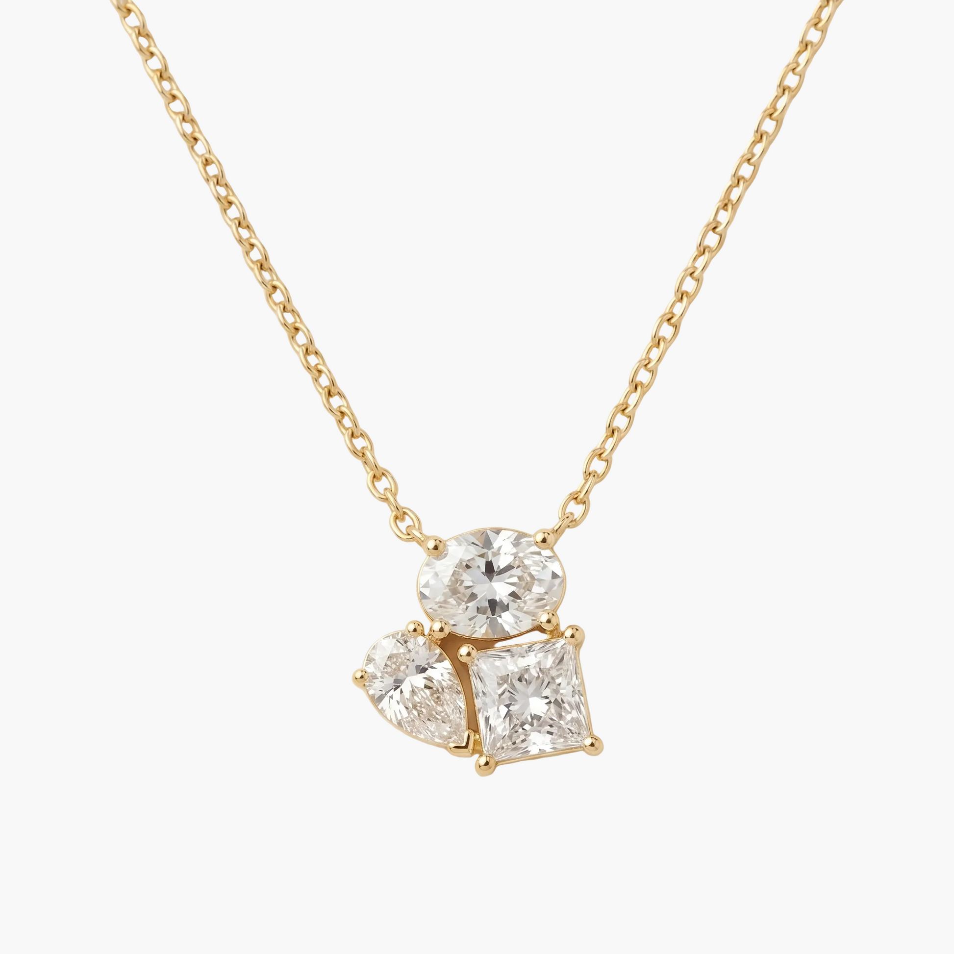Gold necklace with a diamond pendant on a beige background
