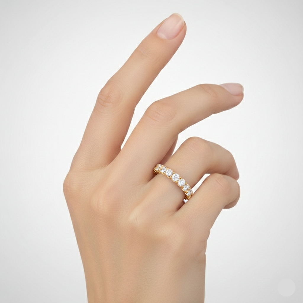 Hand wearing a diamond ring on a light gray background