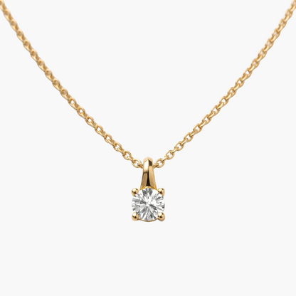 Gold necklace with a diamond pendant on a light gray background
