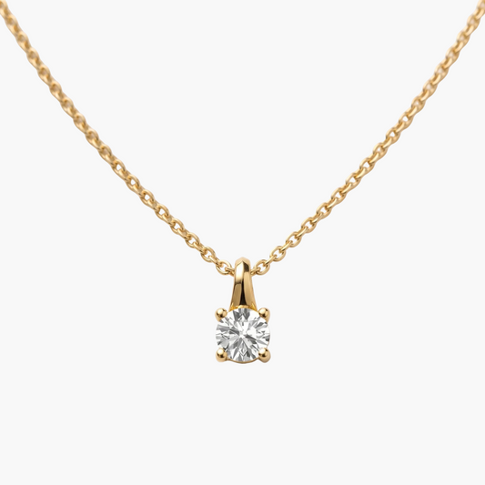 Gold necklace with a diamond pendant on a light gray background