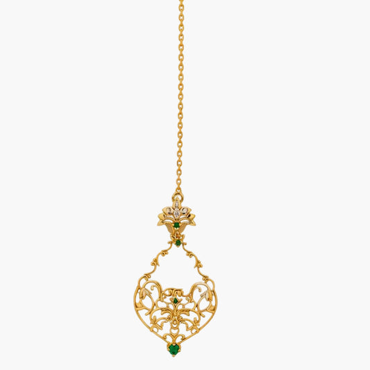Gold necklace with a decorative pendant featuring green gemstones on a white background