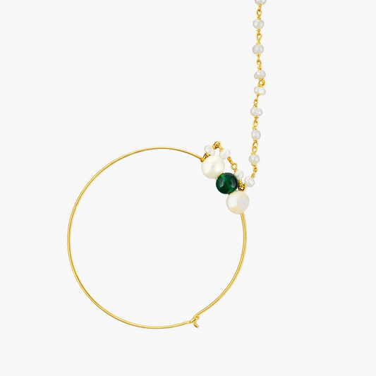 Gold hoop earring with pearls and a green gemstone on a white background