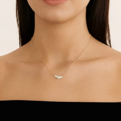 Gold necklace with a heart-shaped pendant on a model against a neutral background