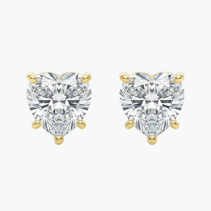 Heart-shaped diamond earrings with gold prongs on a white background