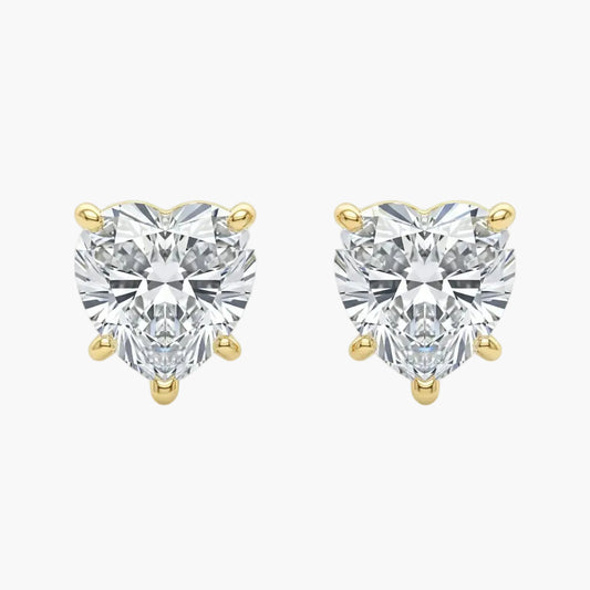 Heart-shaped diamond earrings with gold prongs on a white background