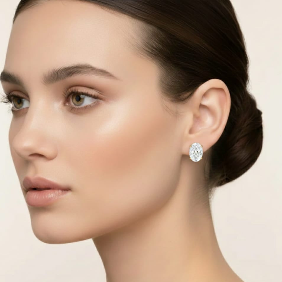 Close-up of a woman wearing diamond earrings on a neutral background