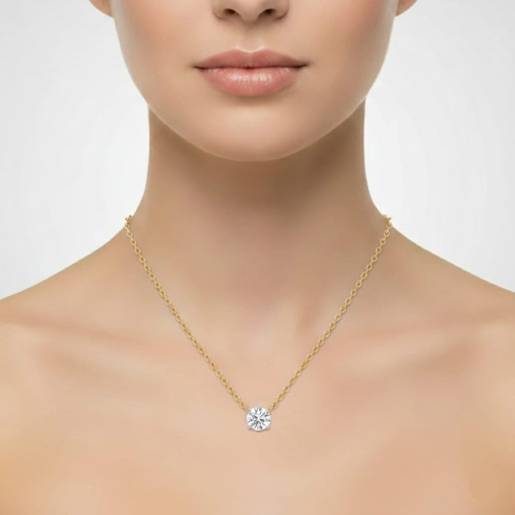 Gold necklace with a diamond pendant worn by a model on a plain background