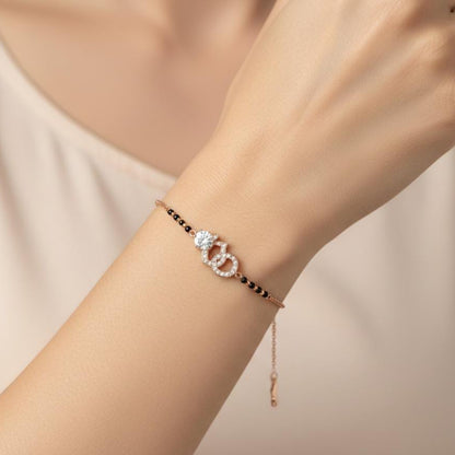 Bracelet with a heart-shaped clasp on a wrist against a neutral background