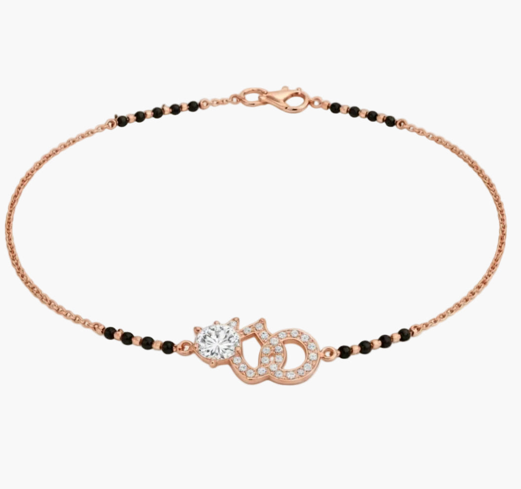 Rose gold bracelet with black beads on a white background