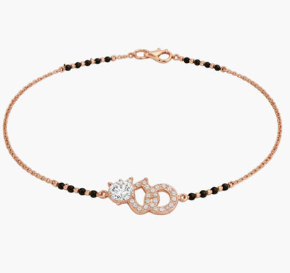 Rose gold bracelet with black beads on a white background