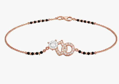 Rose gold bracelet with black beads and a decorative clasp on a white background