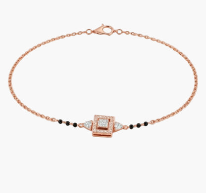 Rose gold bracelet with black beads and a square clasp on a white background