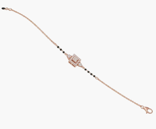 Rose gold bracelet with black beads on a white background
