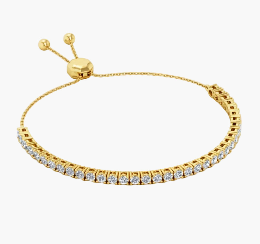 Gold bracelet with clear stones on a white background
