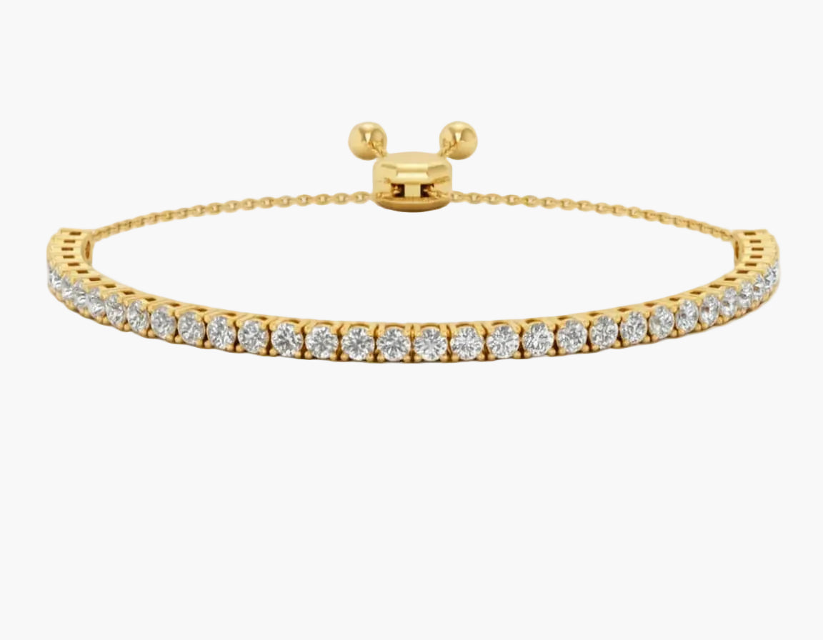 Gold bracelet with diamond accents on a white background