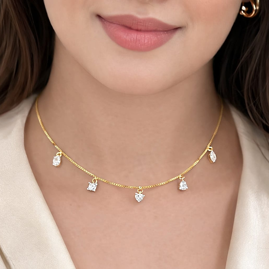 Close-up of a woman wearing a gold necklace with small pendants.