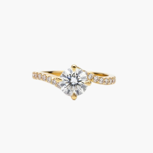 Gold ring with a large diamond and smaller diamonds on the band against a white background