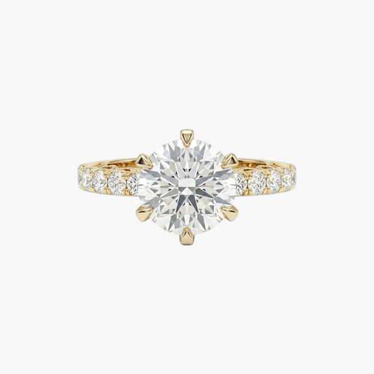 Gold ring with a large diamond and smaller diamonds on the band against a white background