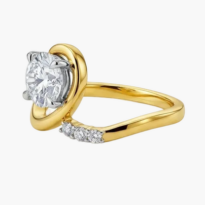 Gold ring with a large diamond and smaller diamonds on the band against a white background