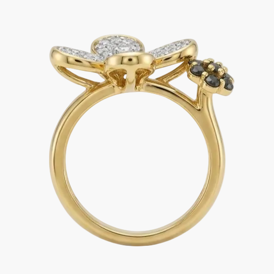 Gold ring with floral designs and gemstones on a white background