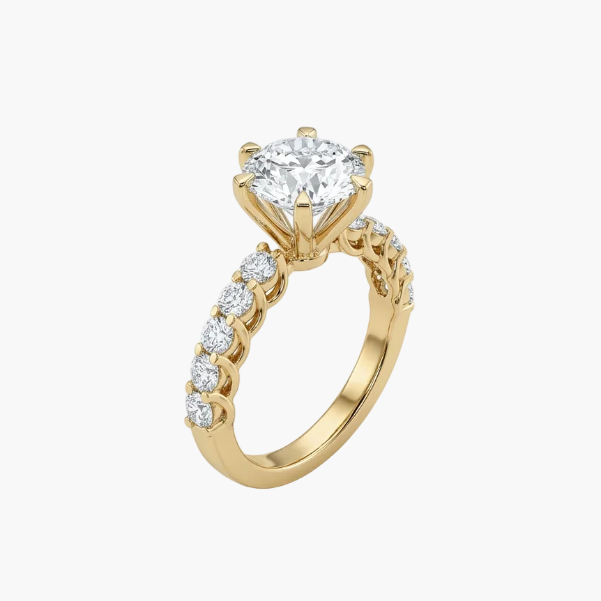 Gold ring with a large diamond and smaller diamonds on the band against a white background