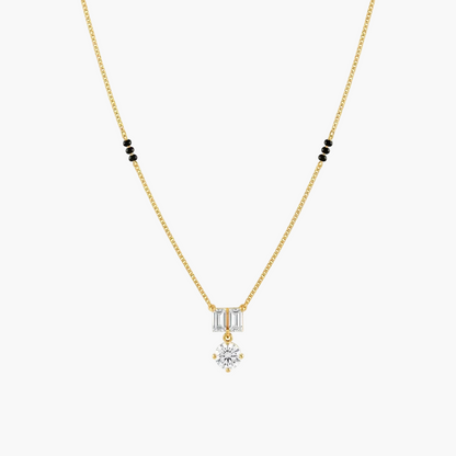 A delicate yellow gold chain necklace featuring a pendant with baguette-cut clear stones and a central round-cut clear stone, accented by small black beads on the chain, shown against a plain white background.