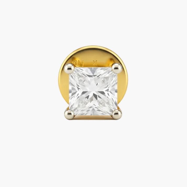Gold earring with a clear gemstone on a white background