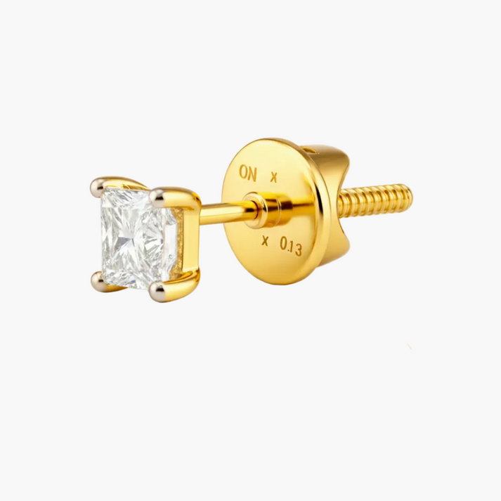 Gold earring with a clear gemstone on a white background