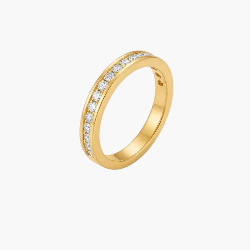 A yellow gold eternity-style ring with a channel-set row of clear stones on one side, photographed on a clean white background.