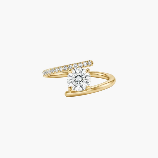 A yellow gold ring with a round-cut diamond center stone and a pavé band of small diamonds, photographed on a clean white background.