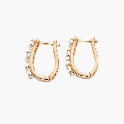 A pair of gold huggie hoop earrings with small clear stones set along the front, displayed on a clean white background.