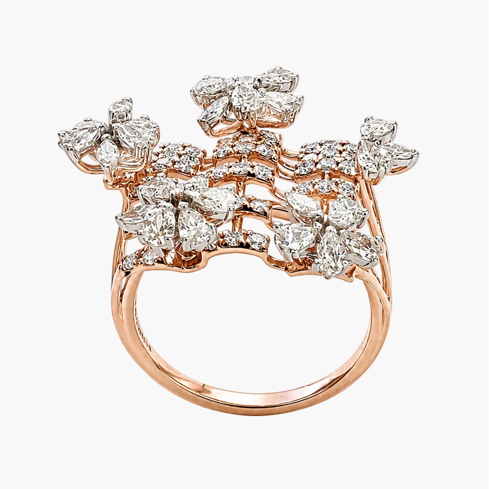 A rose gold ring featuring a large, intricate floral cluster pavé set with numerous clear round diamonds, photographed on a clean white background.