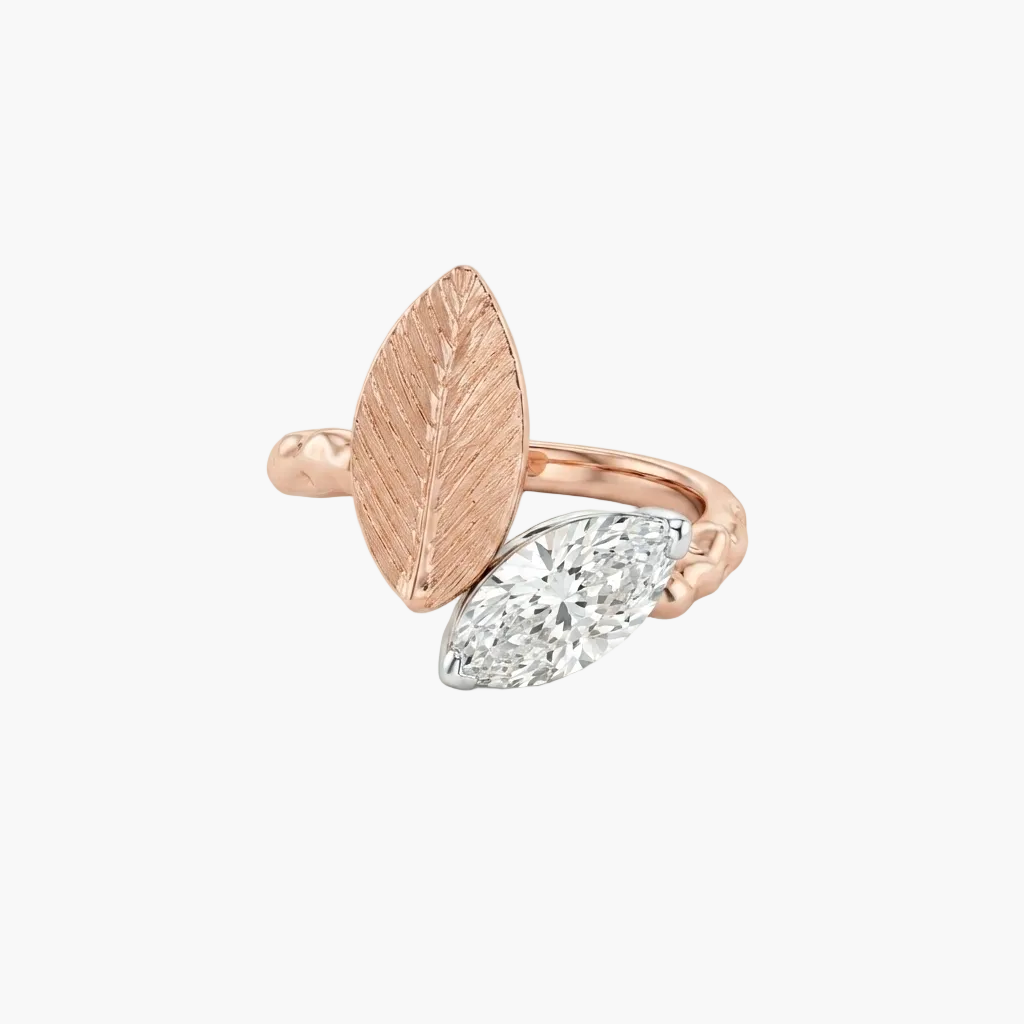 A rose gold ring featuring a textured leaf design with a marquise-cut diamond on the front, set against a clean white background.